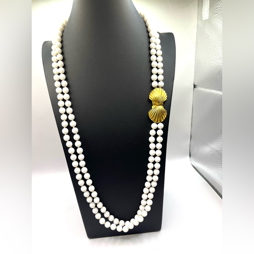 Les Bernard double-strand necklace white beads a gold-tone scallop shell clasp.